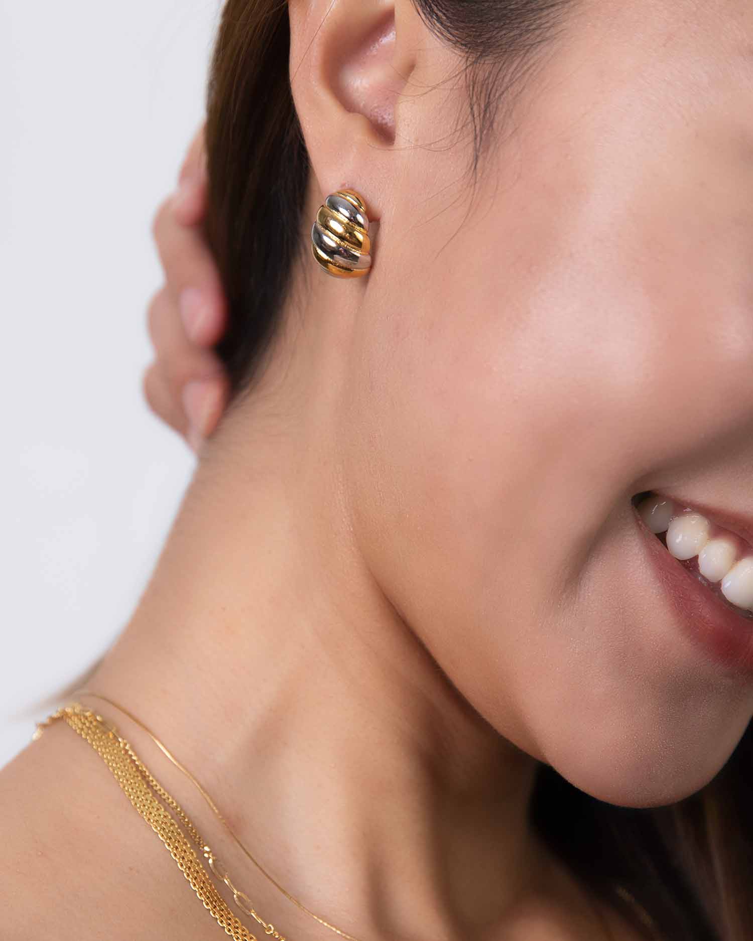 A woman wears Gold and Silver Stud Earrings