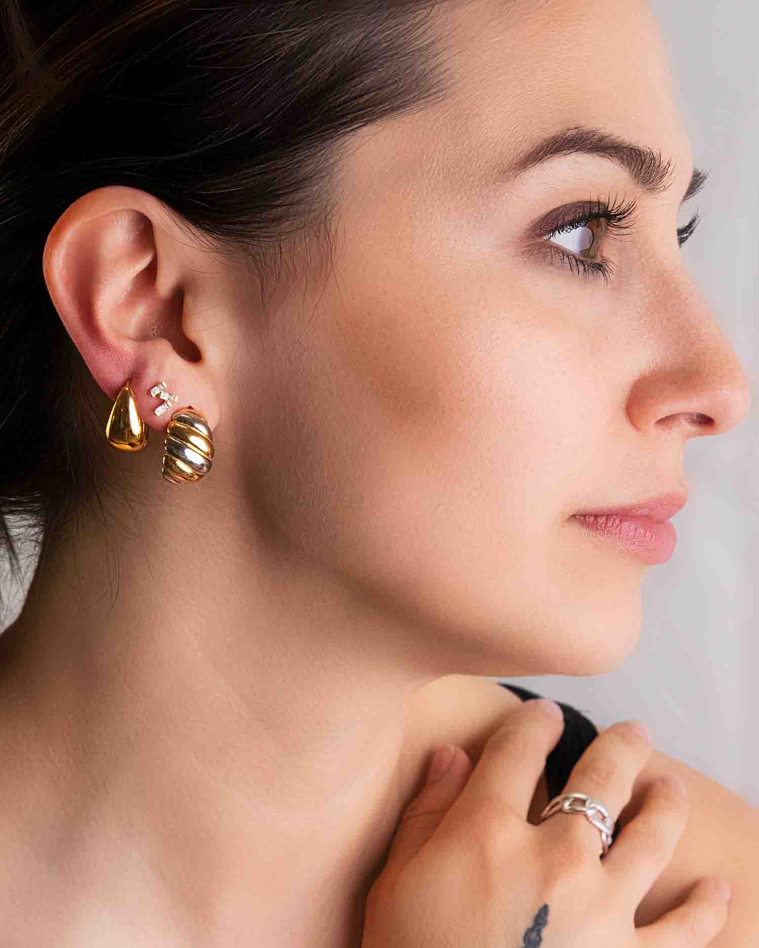 A woman wears Bold Mixed Metal Stud Earrings